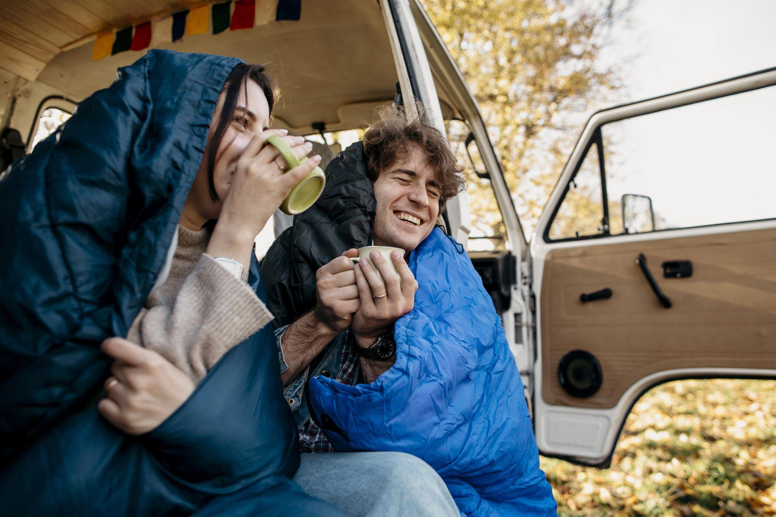 AZAR4 - couple drinking coffee from their van scaled - Jak przygotować kapsułę mobilną na chłodniejsze dni – praktyczny poradnik Azar4